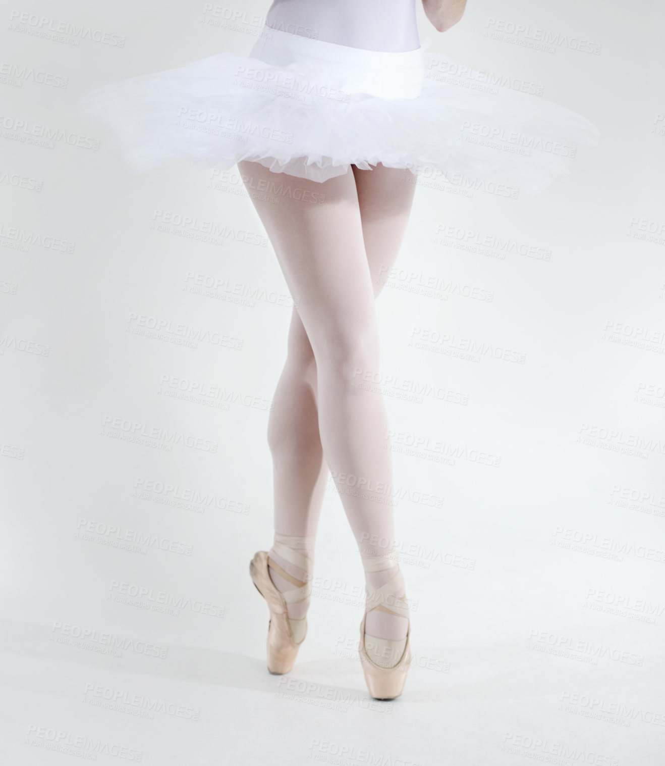 Buy stock photo Ballet dancer, legs and pointe shoes closeup in studio white background for performance, practice or balance. Female person, feet or tutu for artistic expression training, elegant or creative workout