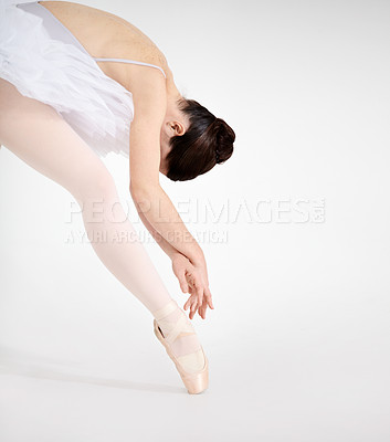 Buy stock photo Dedicated young ballerina dancing en pointe against a white background