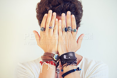 Buy stock photo Hands, face and cover with a man in studio on a white background for fashion or style accessories. Jewelry, bracelet and rings on the fingers of a young model closeup for trendy or edgy expression
