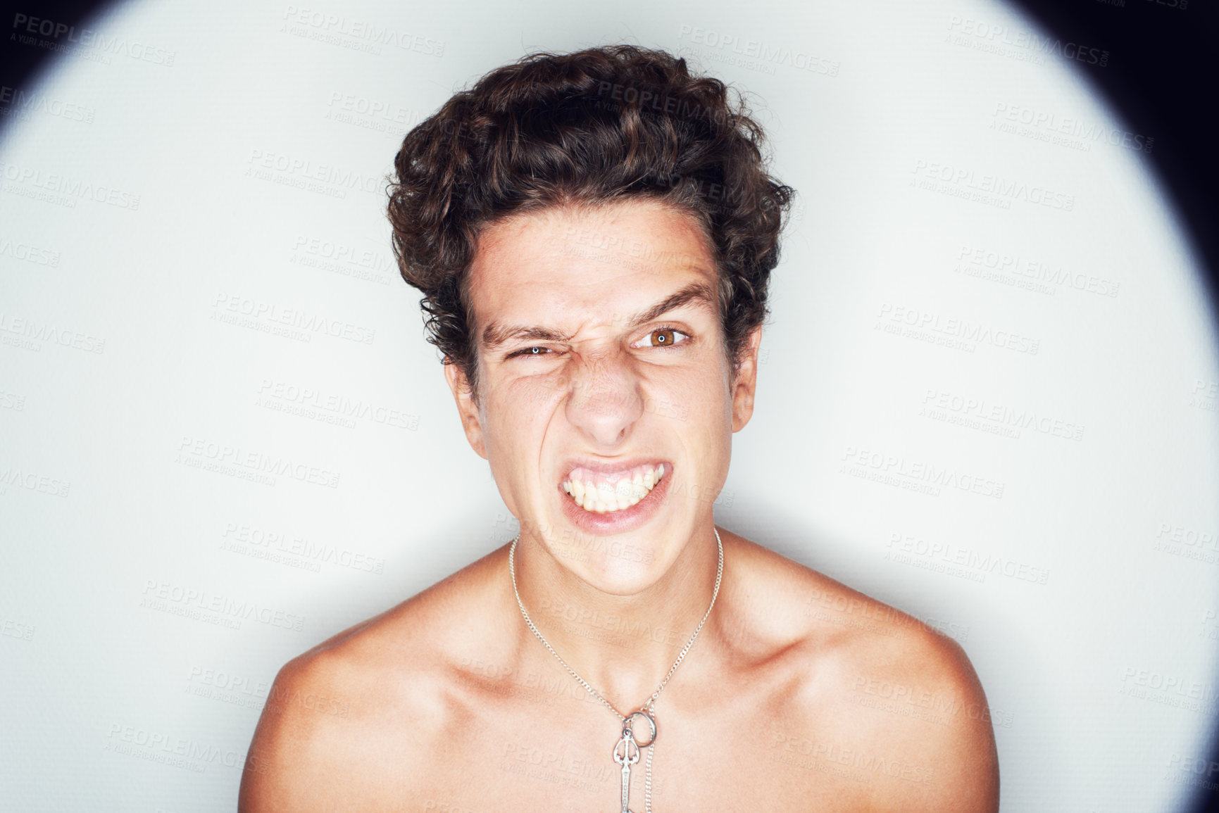 Buy stock photo Studio shot of an angry looking young man surrounded by a big halo of light