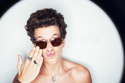 Buy stock photo Man, sunglasses and pout in studio spotlight for fashion, shirtless and edgy punk style by white background. Rock person, halo and hand for kiss with confidence, attitude and jewelry for aesthetic