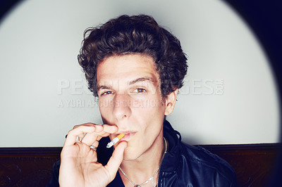 Buy stock photo Portrait of man with cigarette, grunge fashion and rockstar attitude on white background with spotlight. Cool rock style, modern creative and smoking, confident face of handsome male model in studio.
