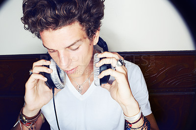 Buy stock photo Man with headphones, rock dj and audio beats with rockstar attitude on white background with spotlight. Cool punk style,  grunge sound and music, club culture with male model listening to earphones.