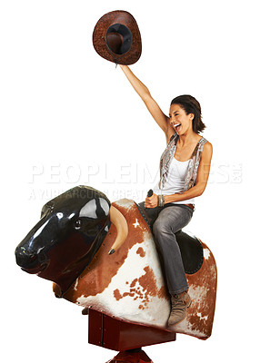 Buy stock photo Studio shot of a beautiful young woman riding a mechanical bull against a white background