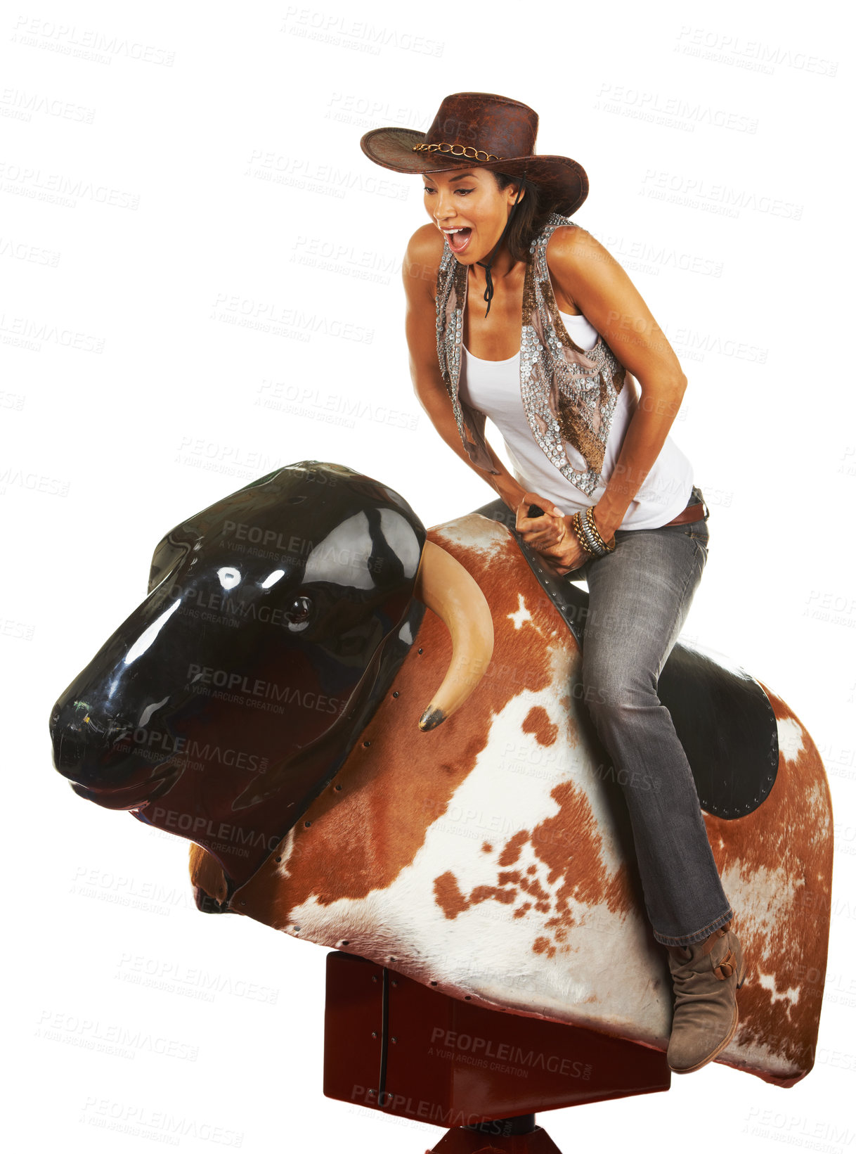 Buy stock photo Studio shot of a beautiful young woman riding a mechanical bull against a white background