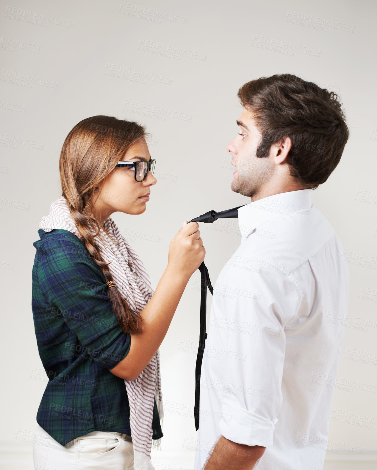 Buy stock photo An angry hipster woman holding her boyfriend by the tie