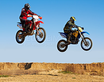 Buy stock photo Action shot of two dirt bikers mid-air