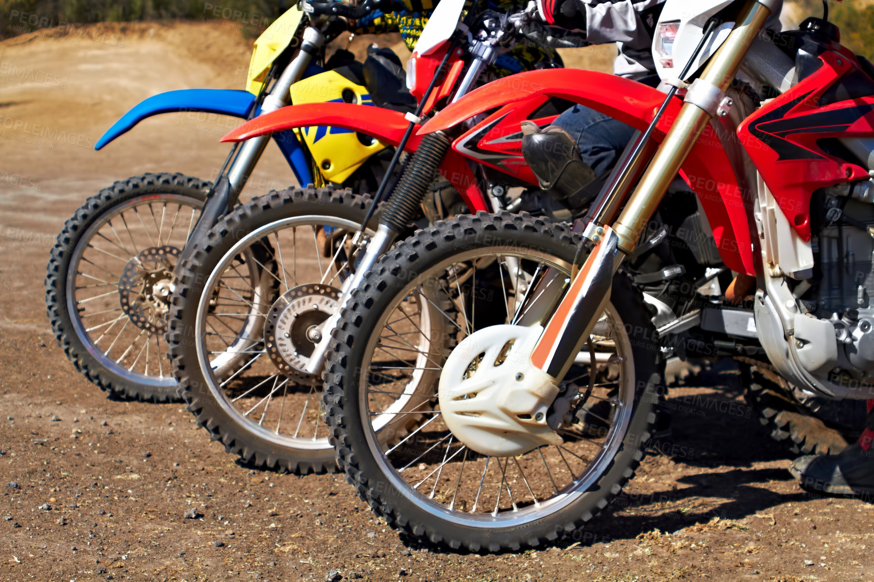 Buy stock photo Three dirt bikes standing in a row