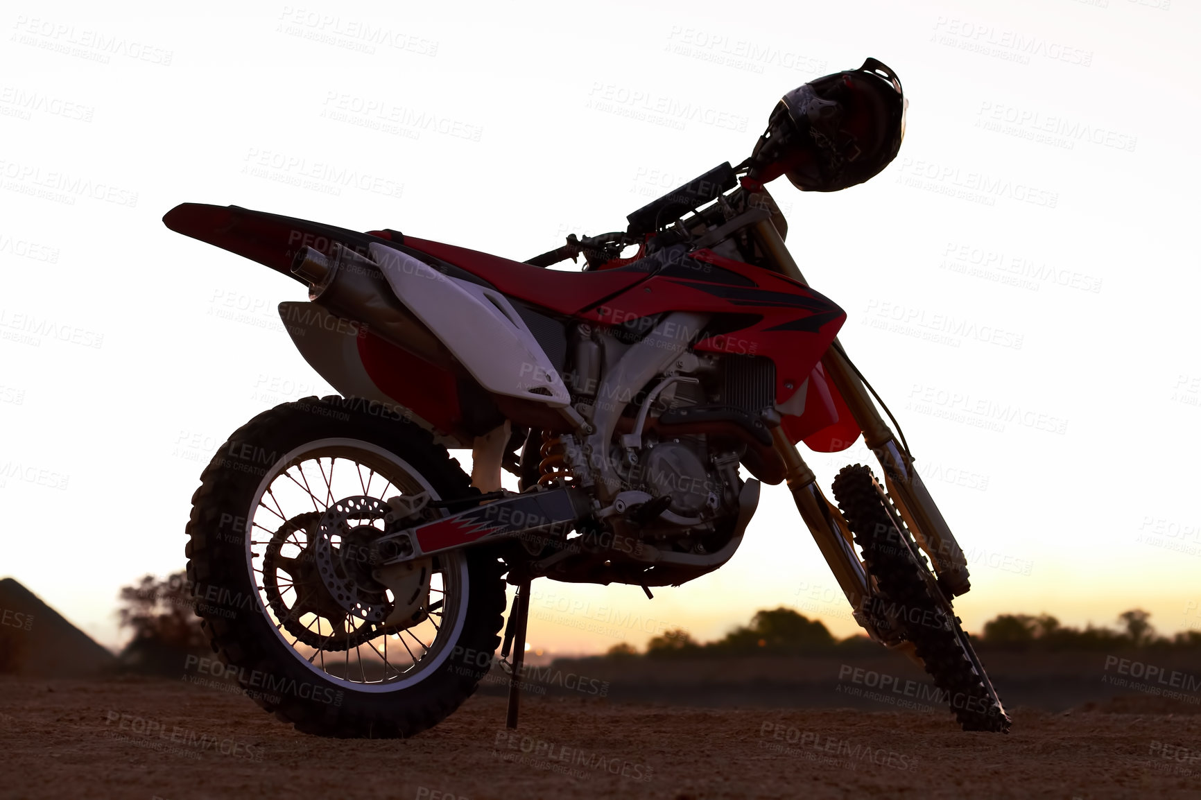 Buy stock photo Dirt, bike and sunset in desert for action danger competition, fast race or speed training. Off road, motorcycle and helmet outdoor for fearless brave adventure, adrenaline or extreme sport transport