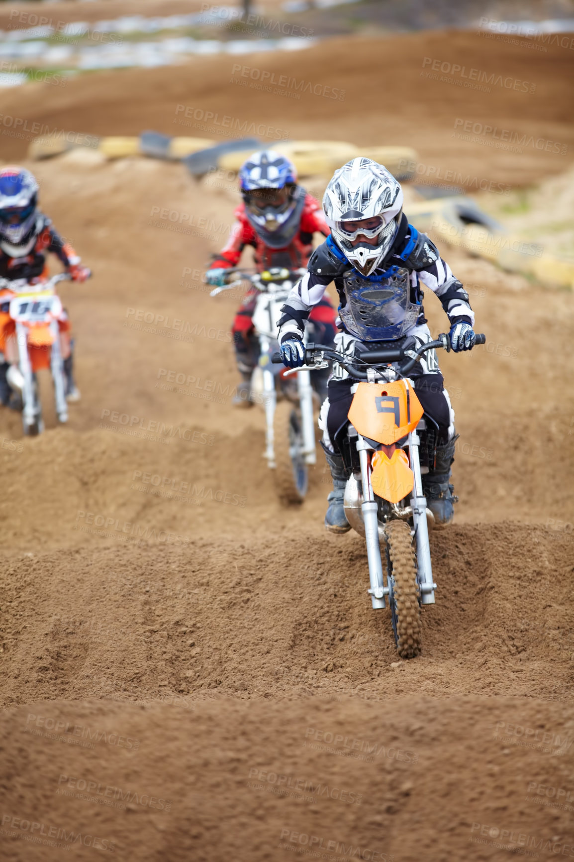 Buy stock photo Three motocross riders riding in close proximity to each other