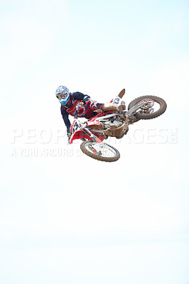 Buy stock photo Blue sky, fitness and man biker jumping for stunt at competition, race or training for skill. Sports, active and male athlete on a motorcycle for energy, adrenaline or adventure with speed in nature.