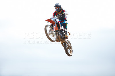 Buy stock photo Blue sky, sports and man biker jumping for stunt at competition, race or training for skill. Fitness, active and male athlete on a motorcycle for energy, adrenaline or adventure with speed in nature.