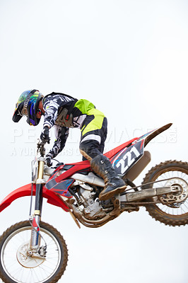 Buy stock photo Sky, fitness and man biker jumping for stunt at competition, race or training for skill. Sports, active and male athlete on a motorcycle for energy, adrenaline or adventure with speed in nature.