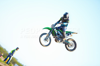 Buy stock photo Person, motorcycle and air stunt in blue sky as professional in action, competition or fearless. Bike rider, off road transportation jump or fast speed adventure at rally, outdoor challenge or race