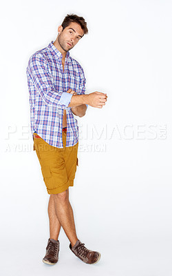 Buy stock photo Casual yet stylish young guy adjusting his cuffs against a white background