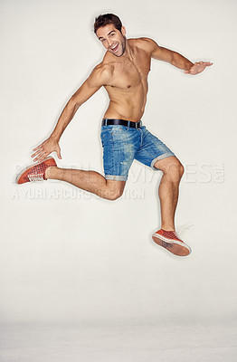 Buy stock photo Muscular young guy jumping in denim shorts while against a white background