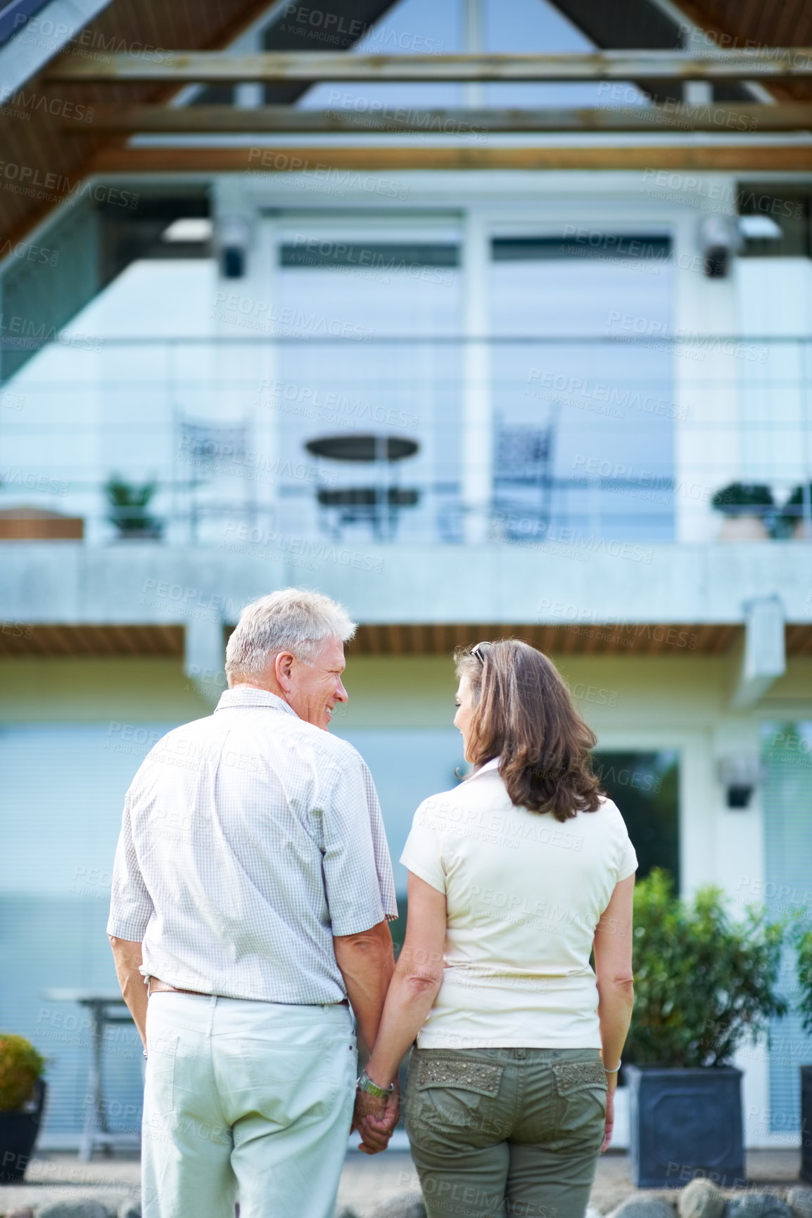 Buy stock photo Senior couple, back and hand holding with smile, happy and holiday home for vacation, retired or outdoor. House, real estate or retirement for break, man or woman for bonding together or love
