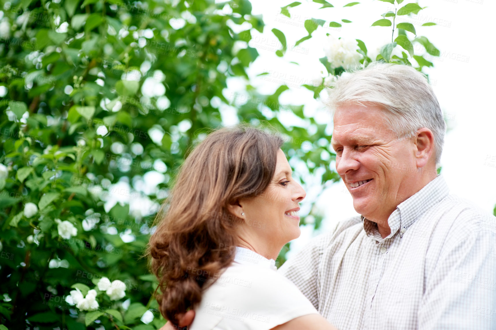Buy stock photo Senior couple, happiness and smiling with hug, park and marriage with embrace, outdoor or retired. Retirement, elderly or love for commitment, bonding or care for romantic relationship, man or woman
