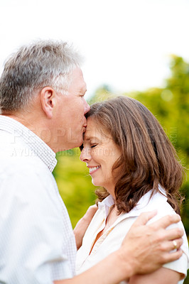 Buy stock photo Senior man, kissing and wife on forehead in park, care and people love for commitment in marriage. France, couple and wellness in nature to connect, hug and happy together in support family on date