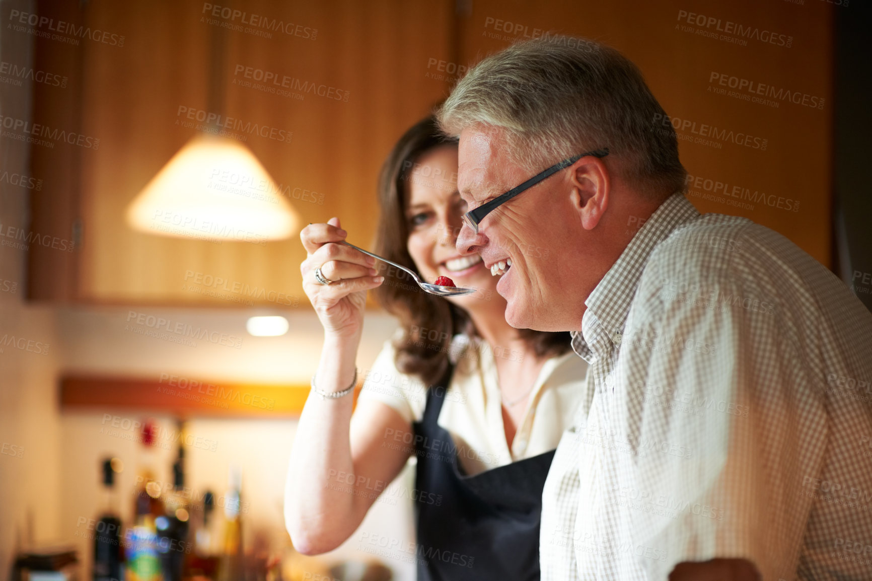 Buy stock photo Cropped shot of a senior couple cooking in the kitchen