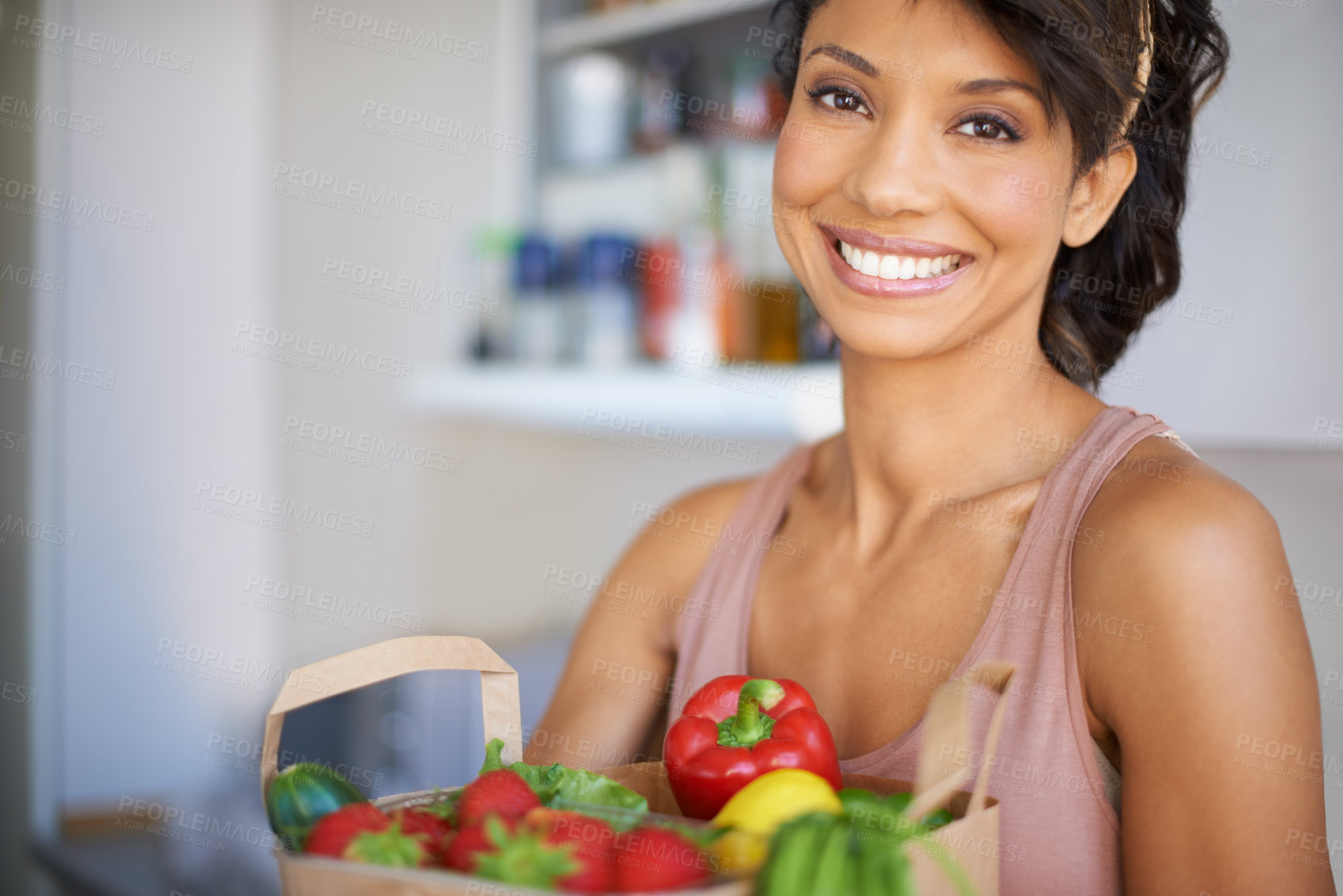 Buy stock photo Portrait of a young woman holding a paper bag of fresh produce