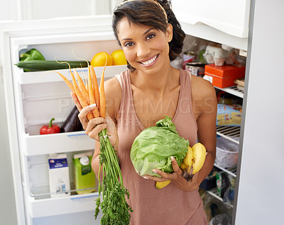 Buy stock photo Portrait a young woman holding fresh produce in a kitchen