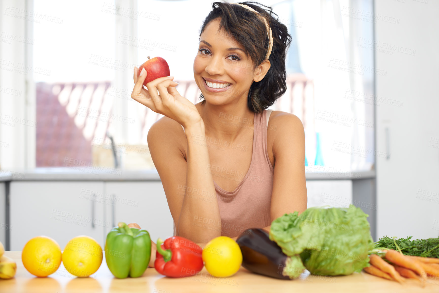 Buy stock photo Portrait of a young woman standing in a kitchen with a line of fresh produce before her