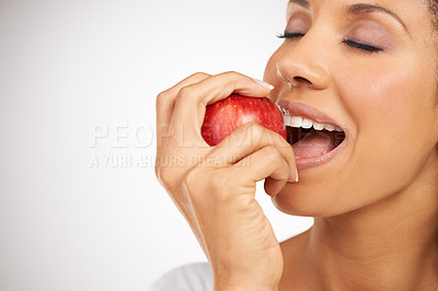 Buy stock photo Happy woman, apple and mouth bite in diet, health or natural nutrition against a gray studio background. Closeup of female person or model eating red organic fruit for fiber, vitamins or healthy meal