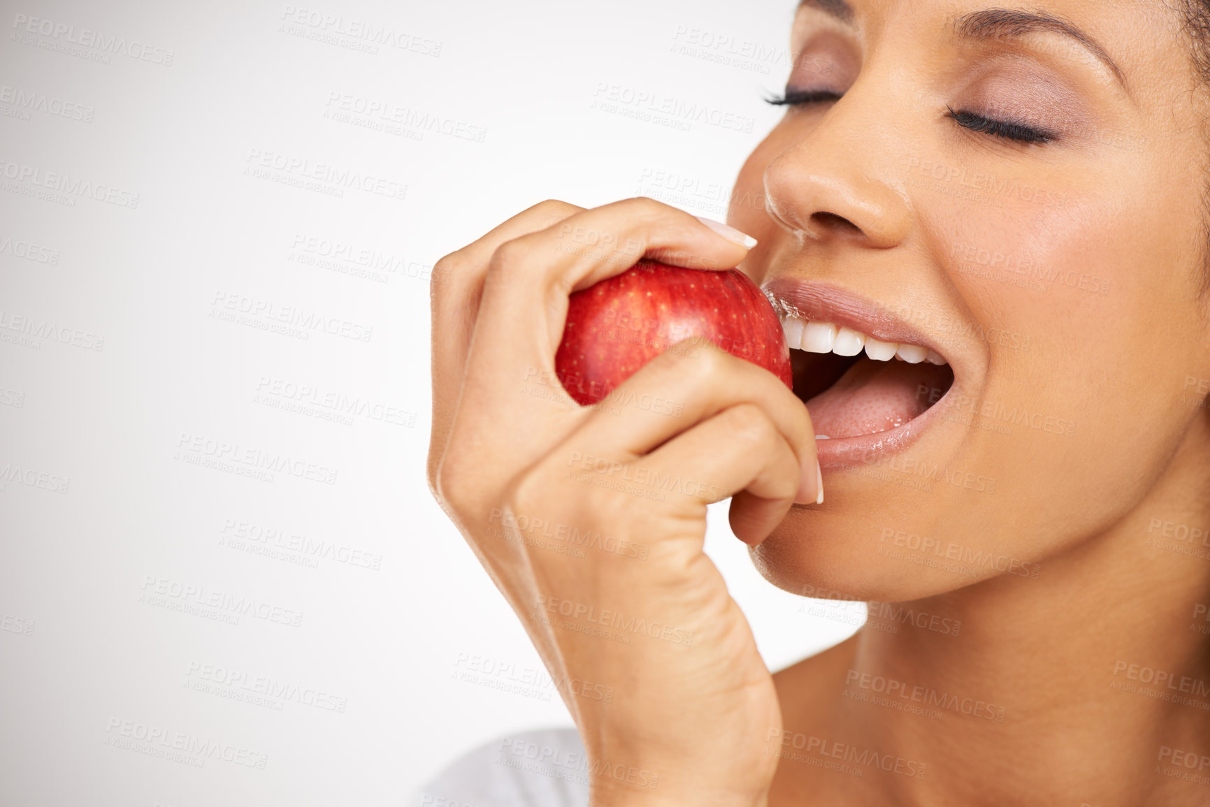 Buy stock photo Happy woman, apple and mouth bite in diet, health or natural nutrition against a gray studio background. Closeup of female person or model eating red organic fruit for fiber, vitamins or healthy meal