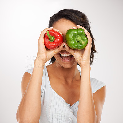 Buy stock photo Face, green and red pepper with a woman in studio on a white background, excited about health, diet or nutrition. Hands, smile and a young person holding vegetables as ingredients for a recipe
