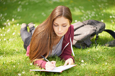 Buy stock photo Woman, student and grass for writing, notebook and planning at university, campus and park for studying. Girl, book and pen for education, learning and brainstorming on lawn at college in sunshine