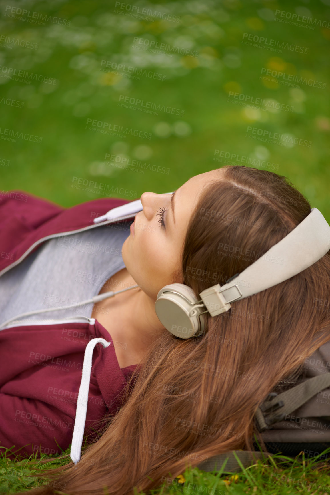 Buy stock photo Woman, student and headphones for music on lawn to relax, summer and audio streaming subscription. Girl, campus grass and park with meditation sound, sleep and peace for listening, radio and podcast