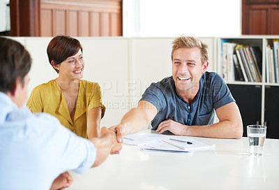 Buy stock photo Shot of a young couple meeting with their financial advisor