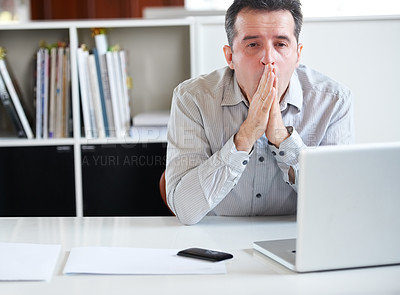 Buy stock photo Portrait of a stressed out-looking businessman sitting in front of his laptop