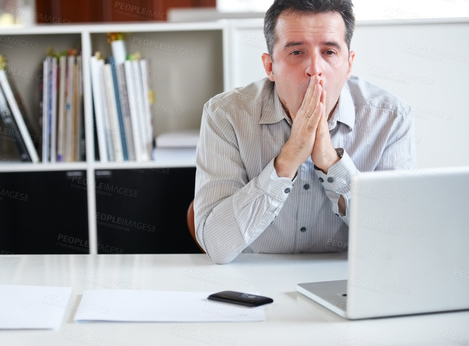 Buy stock photo Portrait of a stressed out-looking businessman sitting in front of his laptop