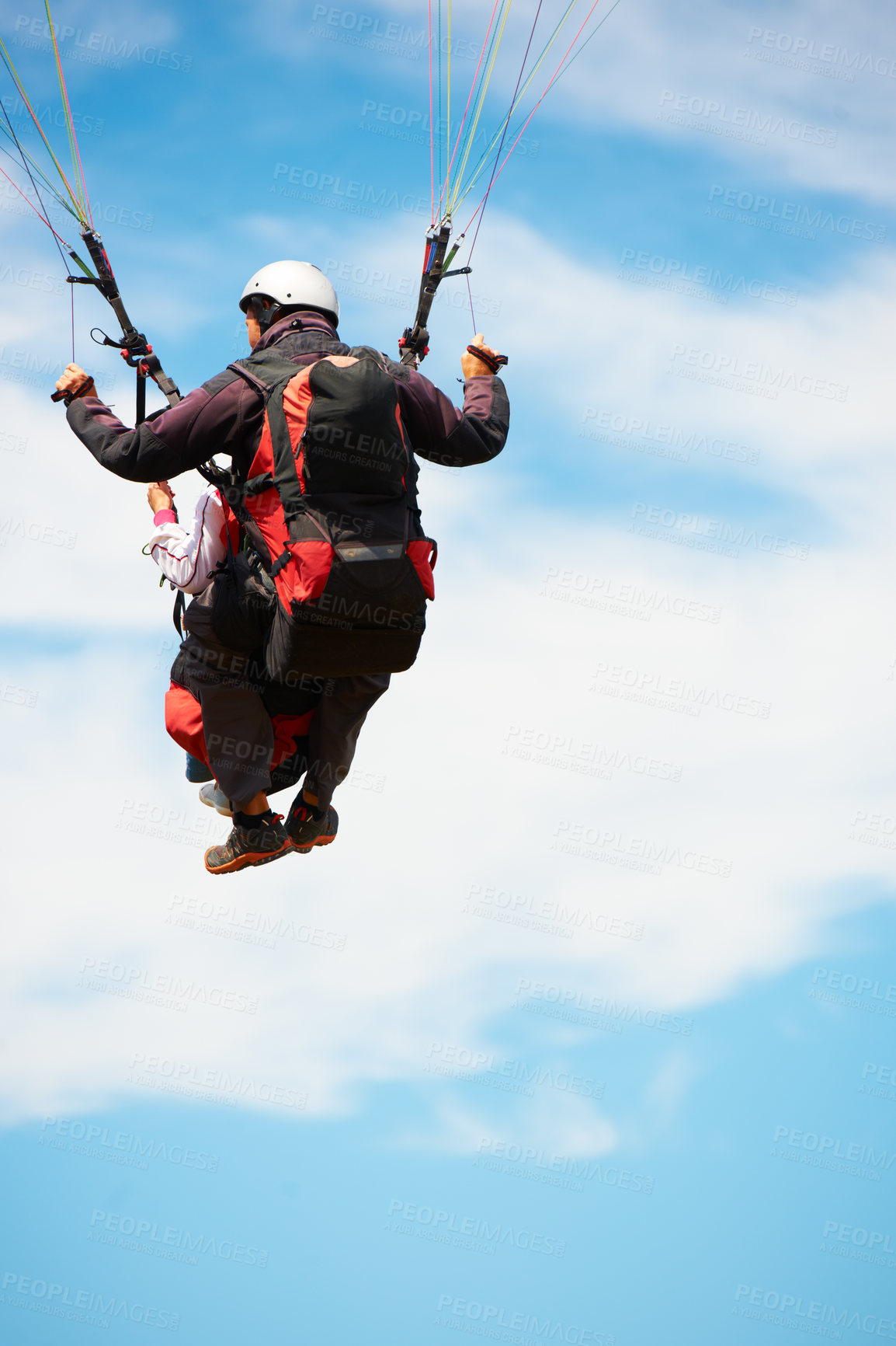 Buy stock photo People, paragliding and freedom in sky, nature and extreme sport with back for fitness. Coach, partnership and person with adventure, helmet and fearless with backpack, parachute and jump with safety