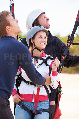 Buy stock photo Two paragliders ready to do a tandem jump being assisted by an instructor