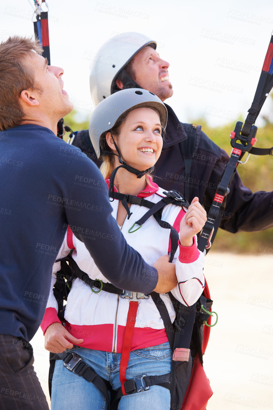 Buy stock photo Two paragliders ready to do a tandem jump being assisted by an instructor