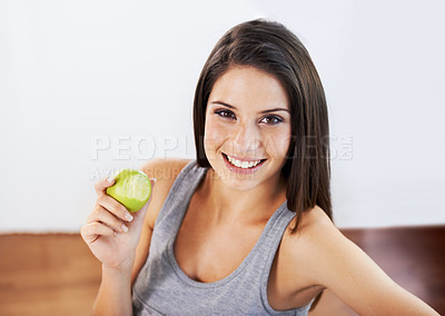 Buy stock photo Portrait, smile and apple with a woman eating food for health, diet or nutrition in the kitchen of her home. Fruit, nutritionist and a happy young model in a house for organic wellness or weight loss