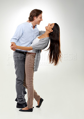 Buy stock photo Couple, holding hands and dancing for valentines day, hug or embrace isolated against a gray studio background. Happy man and woman hugging and enjoying dance in romance for the special month of love