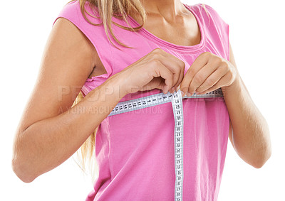 Buy stock photo Cropped shot of a woman measuring her bust with a measuring tape against a white background
