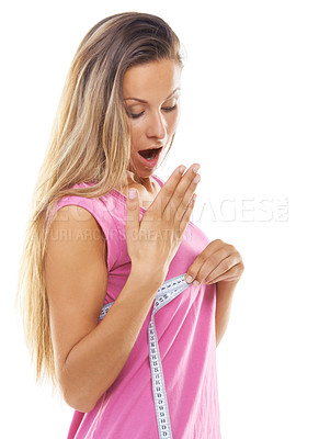 Buy stock photo Studio shot of a gorgeous woman measuring her bust with a measuring tape against a white background