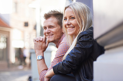 Buy stock photo A cute young couple sitting on their doorstep and looking out the street