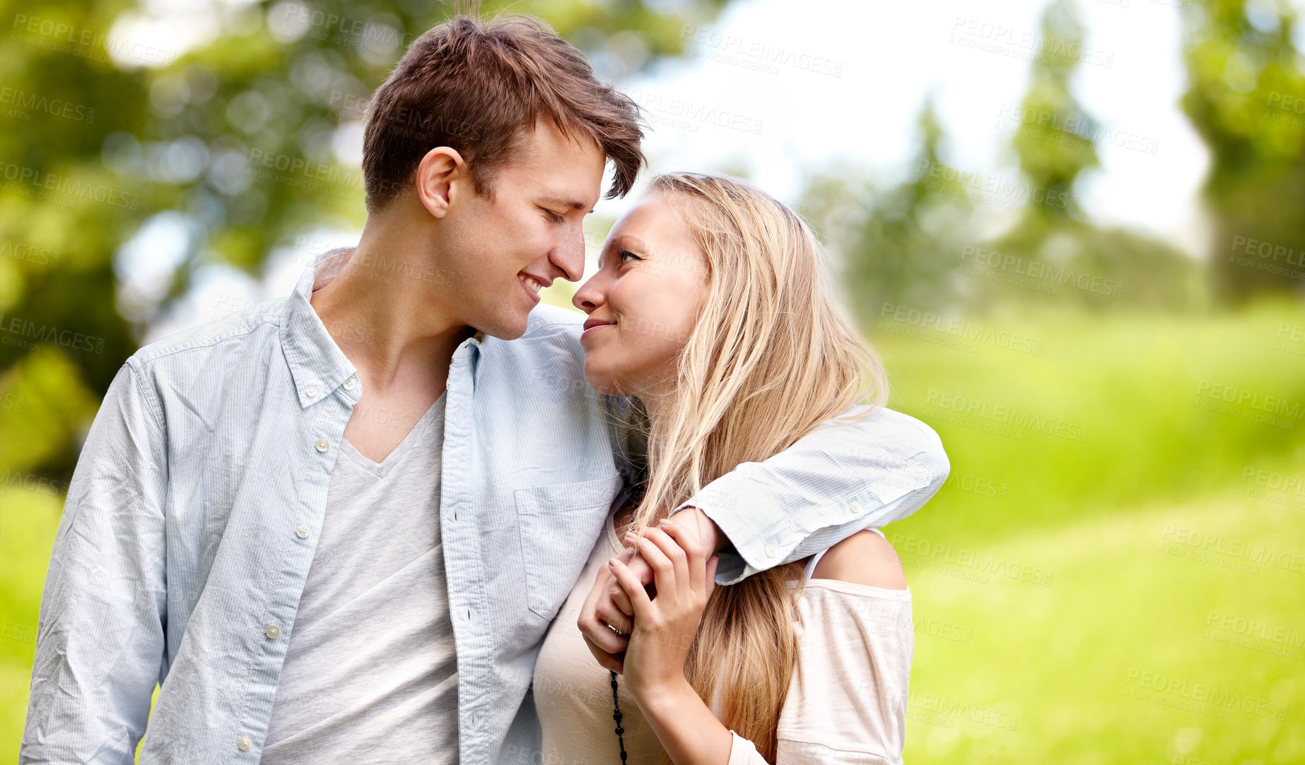 Buy stock photo Young couple standing together in the park
