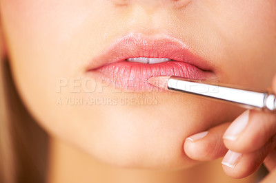 Buy stock photo Cropped view of a young woman's lips as lipstick is applied to them