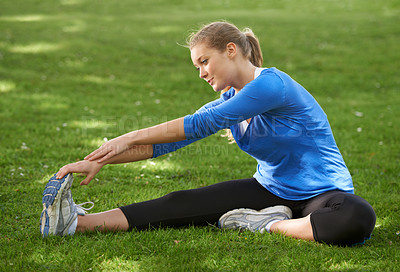 Buy stock photo Woman, runner and stretching legs on grass, park or outdoor at start of exercise or workout. Female, athlete or person in warm up with shoes on feet with fitness, preparation or healthy routine