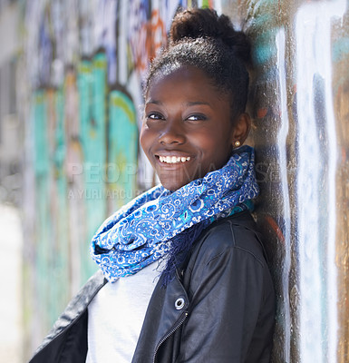 Buy stock photo Portrait of a beautiful young woman leaning against a wall in the city