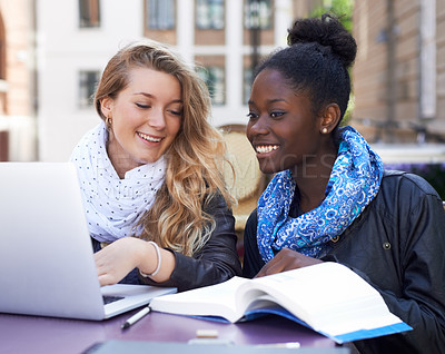 Buy stock photo Communication, women students at campus with laptop and book. Teamwork or collaboration, females working together on university or college assignment and friends laughing or smiling at table