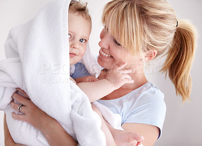 Buy stock photo Cropped shot of a baby boy in a towel being held by his mother