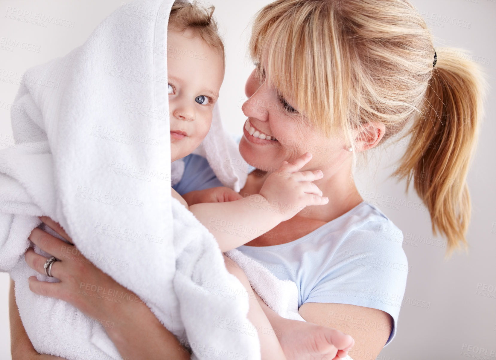 Buy stock photo Cropped shot of a baby boy in a towel being held by his mother